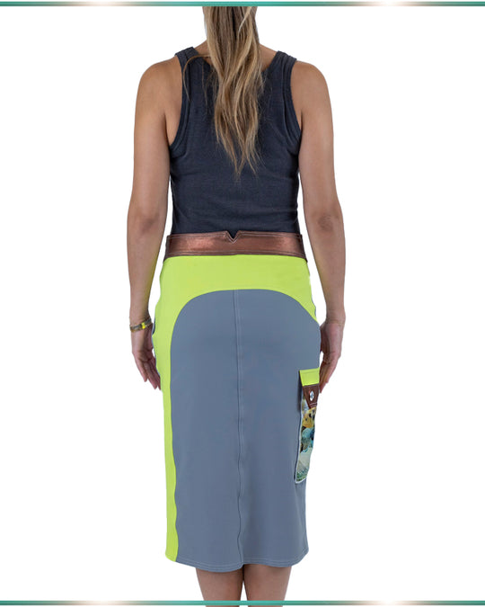 model facing back showing off the lime yoke of the gray, pencil skirt with colorblocing desing