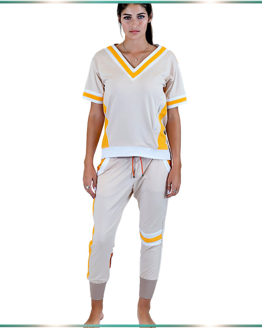 A full view of a model wearing the ivory top and pants set, with orange and white stripes facing forward